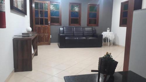 瓜拉派瑞Pousada Paraiso Guarapari的客厅配有黑色真皮沙发和桌子