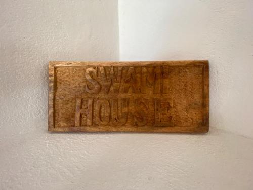 瓦塔穆Swami - Maisha Resort的墙上的木标,字眼巧妙