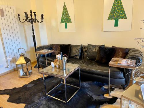 罗卡拉索Casa Montagne的客厅配有真皮沙发和圣诞树