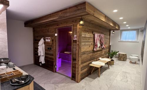 布鲁尼科B&B Obermair的浴室设有木制墙壁和紫色淋浴