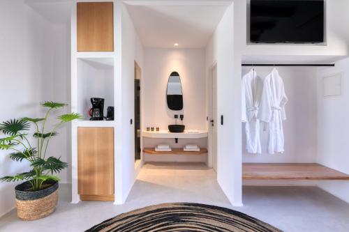 阿格拉瑞Agrari Bo Suites by Mykonos Rocks的一间白色墙壁的浴室和墙上的电视