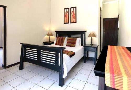 巴利托Ocean View Villas的一间卧室配有黑色的床和2个床头柜
