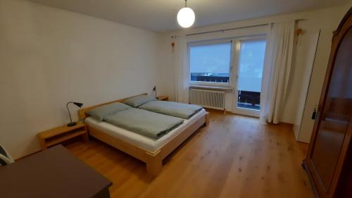 因斯布鲁克Apartment Kirchmair的一间卧室设有一张床和一个大窗户