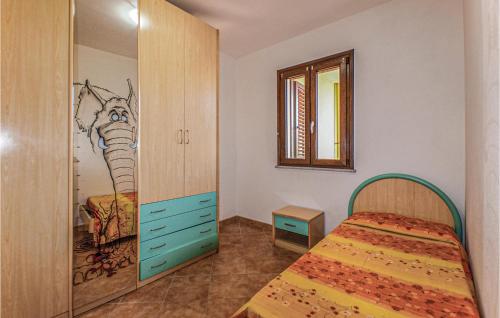 卡斯特尔萨多2 Bedroom Beautiful Apartment In Castelsardo的卧室配有一张床,墙上挂有绘画作品