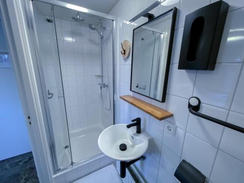 卡茨休维尔Hotel de Slapende Hollander的一间带水槽、淋浴和镜子的浴室