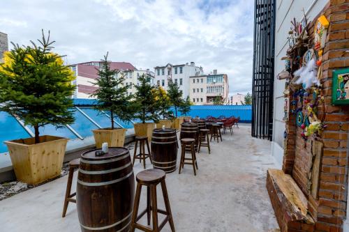 卡尔斯GRAND ANİ HOTEL的阳台上的酒吧凳子和桌子排