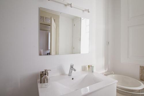 维塞乌Casa da Judiaria Velha的白色的浴室设有水槽和镜子