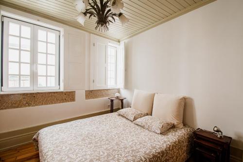 维塞乌Casa da Judiaria Velha的一间卧室设有一张床和两个窗户。