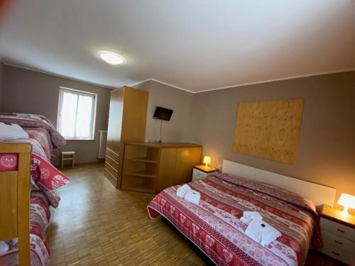 马津索吉奥诺德罗米特酒店的酒店客房带两张床和梳妆台