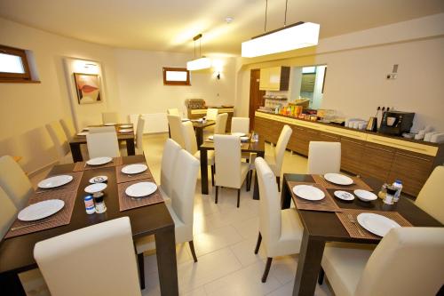 豪伊杜索博斯洛佩泽欧健身机场酒店的用餐室配有木桌和白色椅子