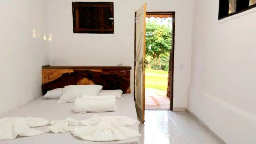 PlanaltinaFazenda Hotel Bem Ecológico的一间卧室配有一张带白色床单和镜子的床