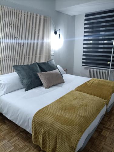 萨拉曼卡Luxury Family Homes M的卧室配有带蓝色枕头的大型白色床