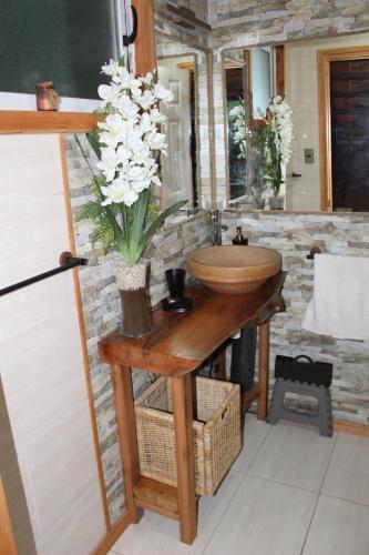 普孔Casa Loft Küme Felen的一间带水槽和花瓶的浴室