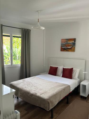 丰沙尔Luxury View Apartment Funchal的卧室配有带红色枕头的大型白色床