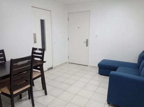 巴拿马城Doña Nancy的客厅配有桌子和蓝色沙发