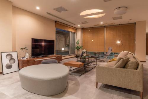 大阪Bijou Suites AI PREMIUM的带沙发和电视的客厅