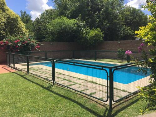 富内斯Casa Departamento Funes Bella Vista Wifi Cochera Pileta的院子中游泳池周围的围栏
