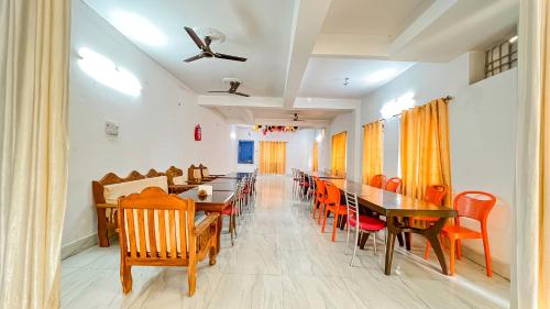 NalandaHotel Nalanda Guest House的一间带长桌和椅子的用餐室