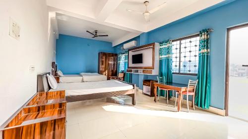 NalandaHotel Nalanda Guest House的一间拥有蓝色墙壁的卧室,配有一张床和一张桌子