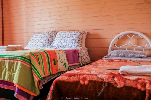 乌鲁比西Pousada Sítio Do Trevo的一间卧室设有两张床和木墙