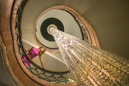 安曼安曼凯悦大酒店的一位女士沿着带吊灯的螺旋楼梯走下