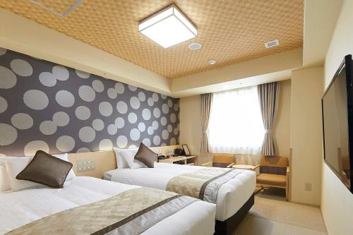 大阪Hot Spring from Deep Water Osaka Hinode Hotel Nipponbashi的酒店客房设有两张床和窗户。