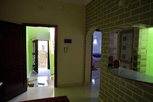 阿斯旺Nubian Queen Guest House的走廊上设有绿色的墙壁和砖墙