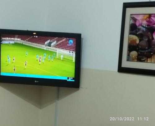苏尔Al Basateen Hotel Apartment的墙上的电视,上面有足球比赛