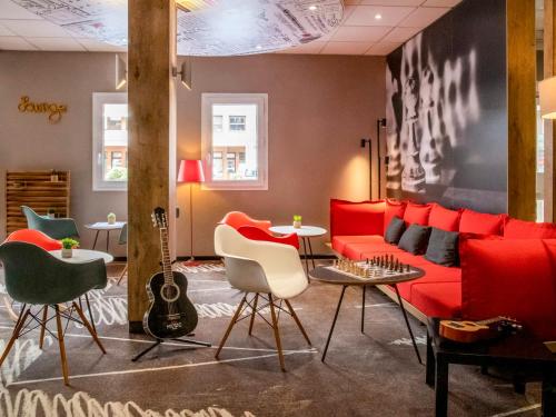 加普ibis Gap Centre的客厅配有红色沙发和吉他