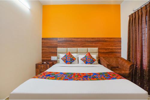 班加罗尔FabHotel Greenwood Xpress的一间卧室配有一张橙色墙壁的床
