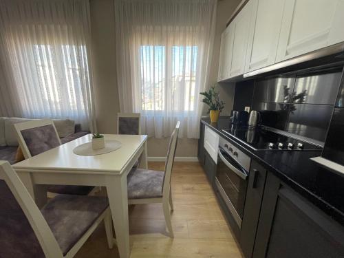 地拉那Tirana New Bazaar- Apartment no-1的一间带桌子和白色桌子的厨房和一间带炉灶的厨房