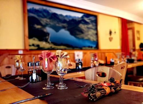 博福特Hôtel du Grand-Mont的餐厅里一张桌子,上面放着酒杯