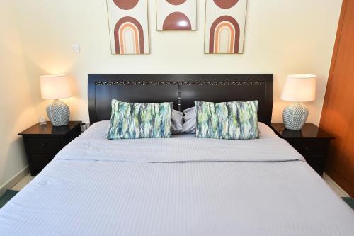 迪拜Lovely 1 Bedroom Apartment in Greens - ADN的一间卧室配有一张大床和两盏灯