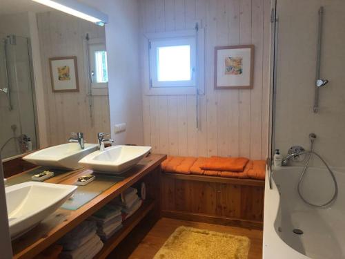 泰哈姆山麓弗拉德尼茨Teichalm Lodge Landhaus的浴室设有2个水槽、浴缸和镜子