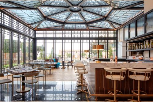 安曼Grand Hyatt Amman Residences的餐厅设有酒吧,配有桌椅