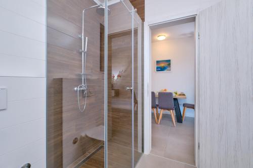 木洛希尼House Torre Apartments的一间带桌子的浴室内的玻璃淋浴间