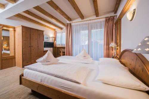 瓦尔道拉阿尔普克龙莫亚里霍夫酒店的一间卧室配有一张带白色床单的大床
