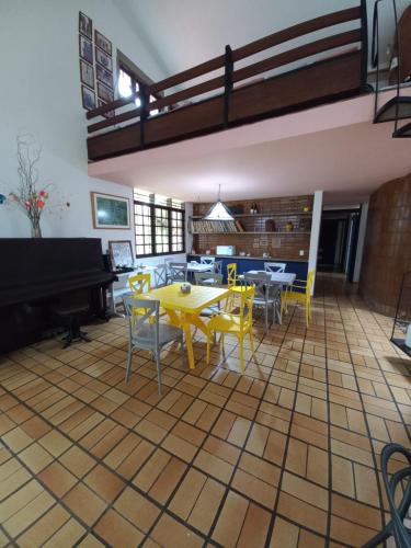 马塞约HOSTEL Recanto do Cajueiro的配有桌椅和钢琴的房间