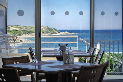 普罗普里亚诺Hôtel Propriano Arena Bianca的海景餐厅设有两张桌子