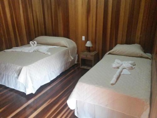 奥林匹亚Pousada Shekinah的两张位于酒店客房的床,配有毛巾