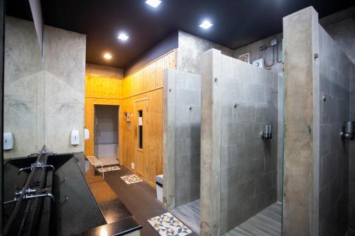 梭桃邑Sea Paradise Hotel Sattahip的带淋浴和盥洗盆的浴室
