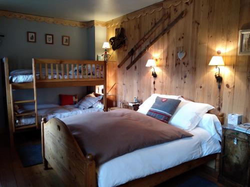 康庞La Grande Ourse的一间卧室设有两张床和木墙