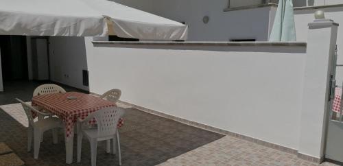 阿韦特拉纳I tre feudi - Casa Vacanza的白色墙壁的房间里摆放着桌椅
