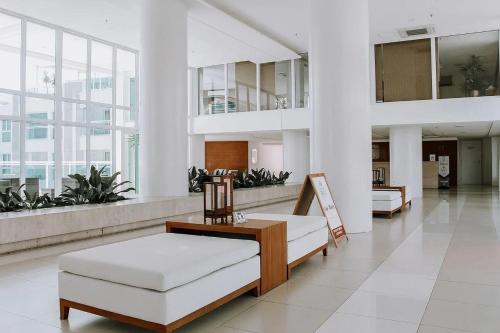 帕纳米林Qavi - Flat em Resort Beira Mar Cotovelo #InMare109的大楼内一个带沙发和椅子的大堂