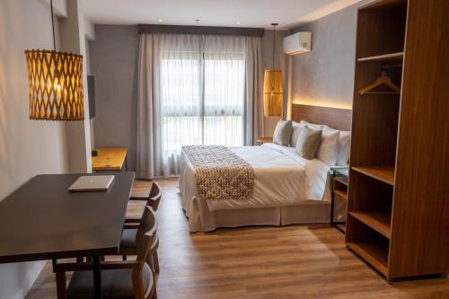彼得罗波利斯Kastel Petrópolis的酒店客房配有一张床铺、一张桌子和一张书桌。