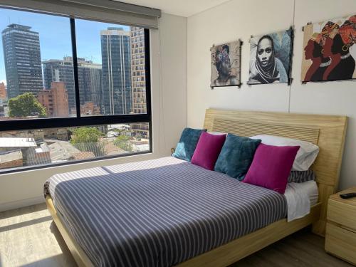 波哥大Apartamento Park Way Bogotá的一间卧室设有一张床和一个大窗户