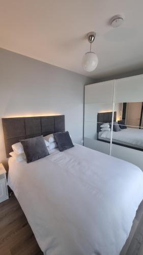 威克洛Entire Modern Home with seaview and parking的卧室内的一张带两个枕头的大型白色床