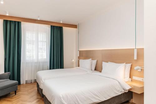 锡比乌Hotel Casa Luxemburg- Newly Renovated的卧室配有一张白色大床和一把椅子