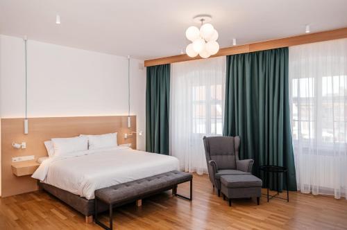 锡比乌Hotel Casa Luxemburg- Newly Renovated的一间卧室配有一张床和一把椅子