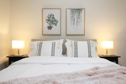 埃德蒙顿Executive Bsmt Suite, King Bed, 5 min to DT & Whyte Ave, Sleeps 6!的一间卧室配有一张带两盏灯的大型白色床。
